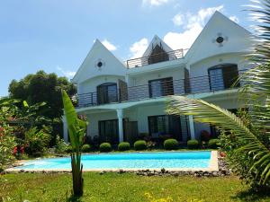 阿姆巴托洛阿卡Villa Malandy Appart Hôtel Duplex 1的一座房子前面设有游泳池