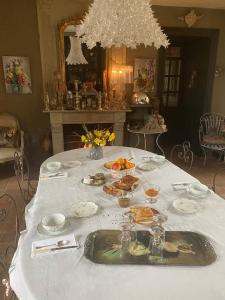 QuintinLa Demeure du Collectionneur的一张桌子,上面有白色的桌布,上面有食物