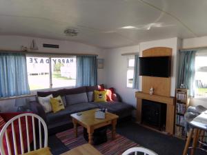 伯克顿Happydaze Caravan的客厅配有沙发和桌子