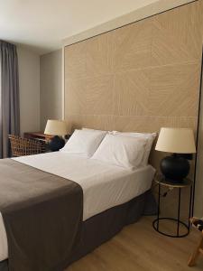 马拉加Apartamentos Málaga Premium - Calle San Telmo的一间卧室配有一张大床和两盏灯