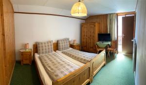 劳特布龙嫩斯坦博克酒店的一间卧室配有一张床、一张书桌和一台电视