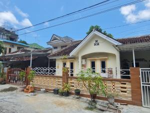 丹戎槟榔OYO 90998 Wisma Pinggir的前面有木栅栏的房子
