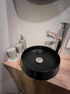 丰冈市城崎温泉 小宿 紬 tsumugi的浴室内木制柜台上的黑水槽