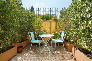 巴塞罗那numa l Roca Rooms & Apartments的植物庭院里的两把椅子和一张桌子