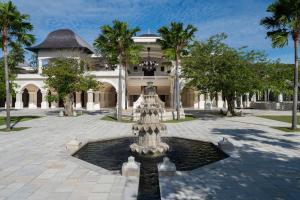 乌鲁瓦图Jumeirah Bali的棕榈树建筑前的喷泉