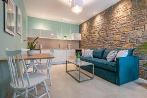 Agios Ioannis KaspakaΑngelikon Luxurious Apartments的一间带蓝色沙发的客厅和一间厨房