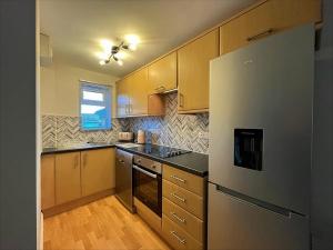 斯托昂泽沃尔德Cotswold apartment with private parking!的厨房配有木制橱柜和冰箱。