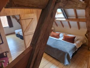MoergestelErfgoed & Logies Den Heijkant的阁楼间设有一张床和两个窗户。