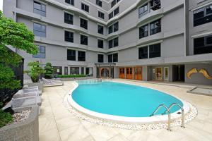 曼谷Oakwood Hotel & Residence Bangkok SHA Plus Certified的大楼前的游泳池