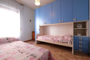 皮内托Malibù 5 Pineto Vacanza的一间卧室配有两张床和蓝色橱柜。