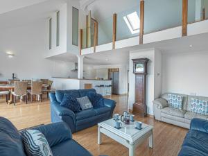 罗斯奈格尔Pass the Keys Celyn Y Mor Stunning Rhosneigr Family Beach House的客厅配有蓝色的沙发和桌子