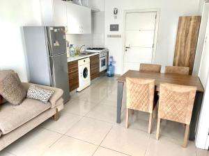 北尼科西亚Beautiful One-Bedroom Apartment Lukomorye B6的厨房配有桌椅和冰箱。