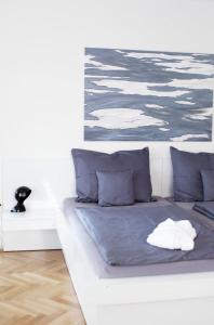 KozÃ¡roviceVilas & Wellness Resort Orlík的一张带蓝色枕头的白色床和绘画