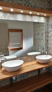 CamélasMas la Mouillere的浴室设有木制柜台上的两个白色水槽