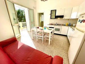 托雷瓦多Le macchie - Vacanza nel verde的一间带红色沙发的客厅和一间厨房
