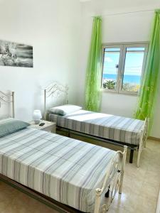 托雷瓦多Le macchie - Vacanza nel verde的一间卧室设有两张床和窗户。