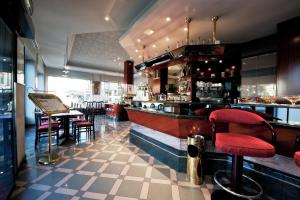 比耶拉米开朗基罗酒店的餐厅设有酒吧,配有红色凳子