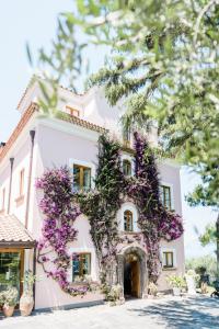索伦托卡波圣福尔图纳塔农家乐的白色的房子,上面有紫色的花
