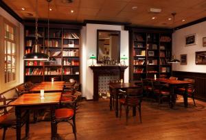 艾瑟尔河畔卡佩勒鹿特丹卡佩里NH酒店的一间带桌椅和书架的餐厅