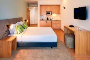 波尔蒂芒NH Marina Portimao Resort的一间带大床的卧室和一间厨房