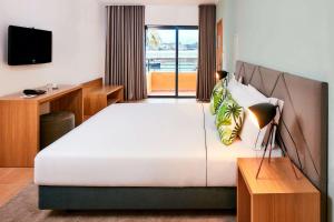 波尔蒂芒NH Marina Portimao Resort的卧室配有一张白色大床和电视。