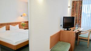 Kupferzell金茨堡兰德酒店的一间酒店客房,配有一张床和一台电视