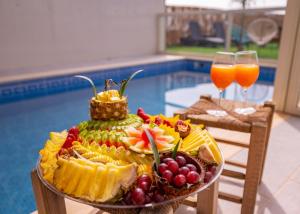 ‘Ein el AsadBlue lake luxury villa for families的桌上一盘水果和两杯果汁