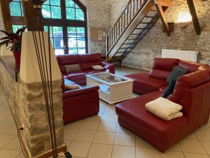 蒙塔尼莱丝比欧尼Maison Belles Pierres的一间带红色沙发的客厅和楼梯