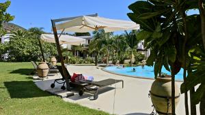 利帕里拉吉尔拉酒店的一个带桌子、遮阳伞和躺椅的游泳池