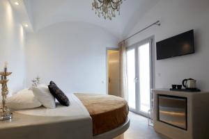 卡马利蓝色海洋酒店的卧室配有一张床,墙上配有电视。