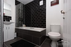 南安普敦Δ Ares Apartment Δ The Flame of Town的黑色瓷砖浴室设有卫生间和水槽