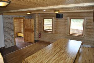 斯米尔泰内Vilks un Briedis Holiday Home & Wellness Area的带木桌的客房,位于带窗户的房间内