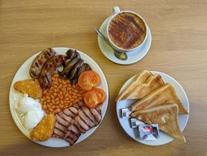 诺里奇Broadview Lodge的餐桌,包括两盘早餐食品和一杯咖啡