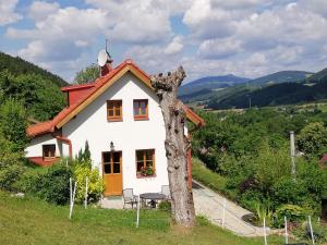 Frýdštejncharming house with beautiful landscape的旁边有一棵树的小白色房子