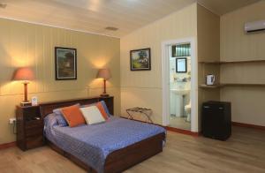 萨拉皮基Horquetas River Lodge的一间卧室设有一张床和一间浴室。