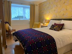 LlanarthParc Farm B&B的一间卧室配有一张带彩色毯子的床
