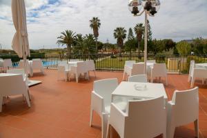圣港INATEL Porto Santo的庭院配有白色的桌子和白色的椅子。