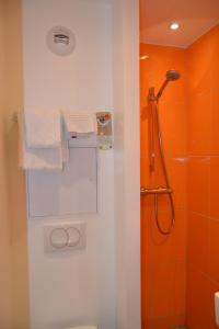 巴黎四季巴黎卡德拉法耶特酒店的浴室拥有橙色的墙壁,配有毛巾和淋浴