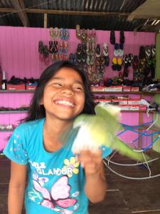 YucurucheLibertad Jungle Lodge的把鸟放在商店里的年轻女孩