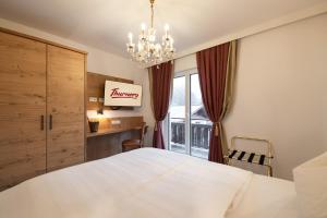 布鲁克安德格罗斯哥Thurners Boutique Hotel的卧室设有一张白色大床和一扇窗户。