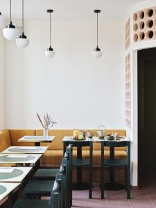 巴黎Hotel Orphée - Orso Hotels的一间设有桌椅和白色墙壁的用餐室