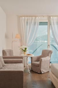 莱泽诺极光别墅酒店的客厅配有两把椅子和大窗户