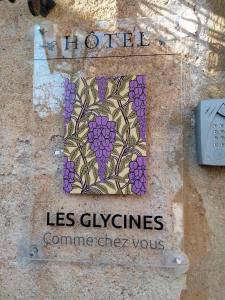 韦兹莱Les Glycines Vézelay的墙上的标志,上面有葡萄的画