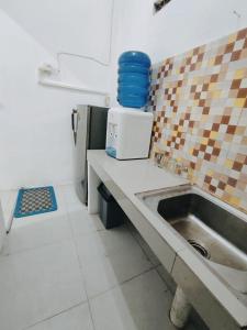 武吉丁宜Dnaiko Syariah Hotel的厨房配有水槽和台面