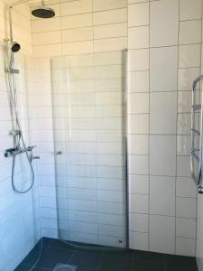 孔艾尔夫Kastellegården Skanskullen的带淋浴的浴室和白色瓷砖墙壁