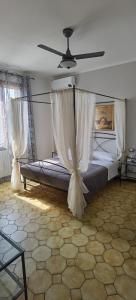 迪拉文纳卡斯蒂利奥内B&B A'la Funtäna的一间卧室配有一张带吊扇的床