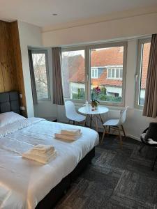 布鲁日Prachtige kamer in centrum Brugge met badkamer !的卧室配有床、桌子和窗户。