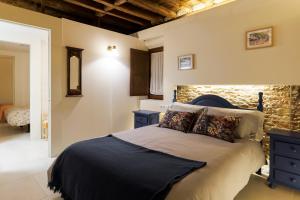 阿尔卡拉德荷那利斯Casa Deluxe Herreros的一间卧室设有一张床和石墙