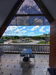 Colinas Do SulPousada Adorno的阳台配有桌椅,享有街道的景色。