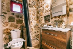 佩萨达Dreamy Stone House的一间带卫生间、水槽和镜子的浴室